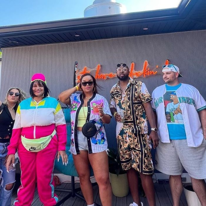 Group of people posing in front of a orange neon sign at The Blue Duck in New London CT