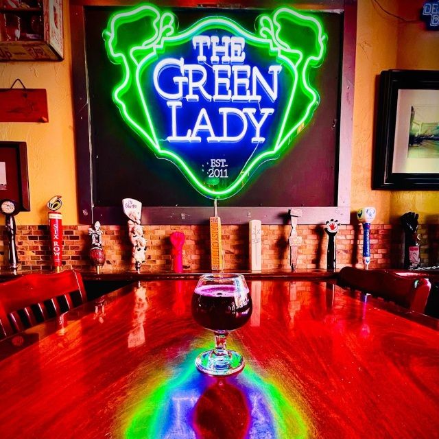 The Green Lady Custom Neon® sign glowing green above a Chicago bar