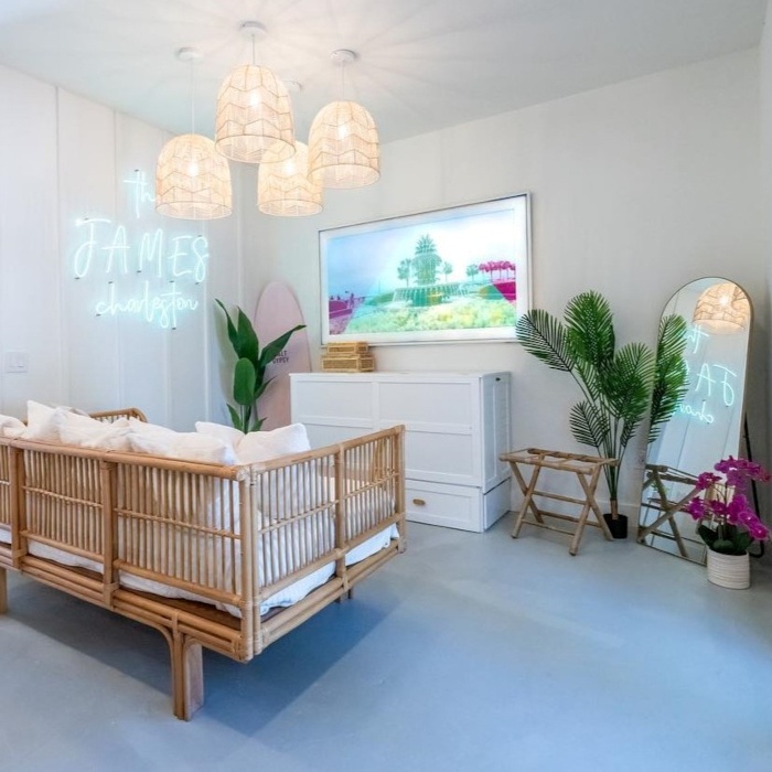 The James Charleston tropical blue Custom Neon® sign on a white wall in the living room @thejamescharleston airbnb