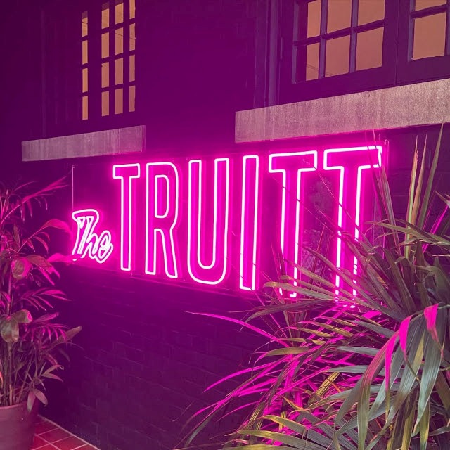 The Truitt Custom Neon® sign in the outdoor lounge area of @thetruitt hotel in Kansas City MO