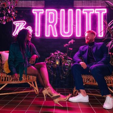 The Truitt large pink Custom Neon® sign in The Truitt hotel with guests seated in the foreground @thetruitt