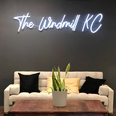 Custom Neon® white cafe sign on a dark wall in the selfie nook @thewindmillkc