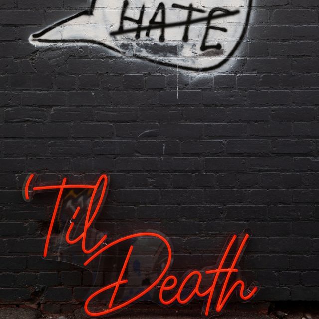 Red Til Death Custom Neon® sign on a black brick wall with graffit