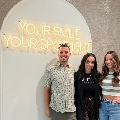 Custom Neon® warm white Your Smile Your Spotlight sign on a white feature wall @gleemdental