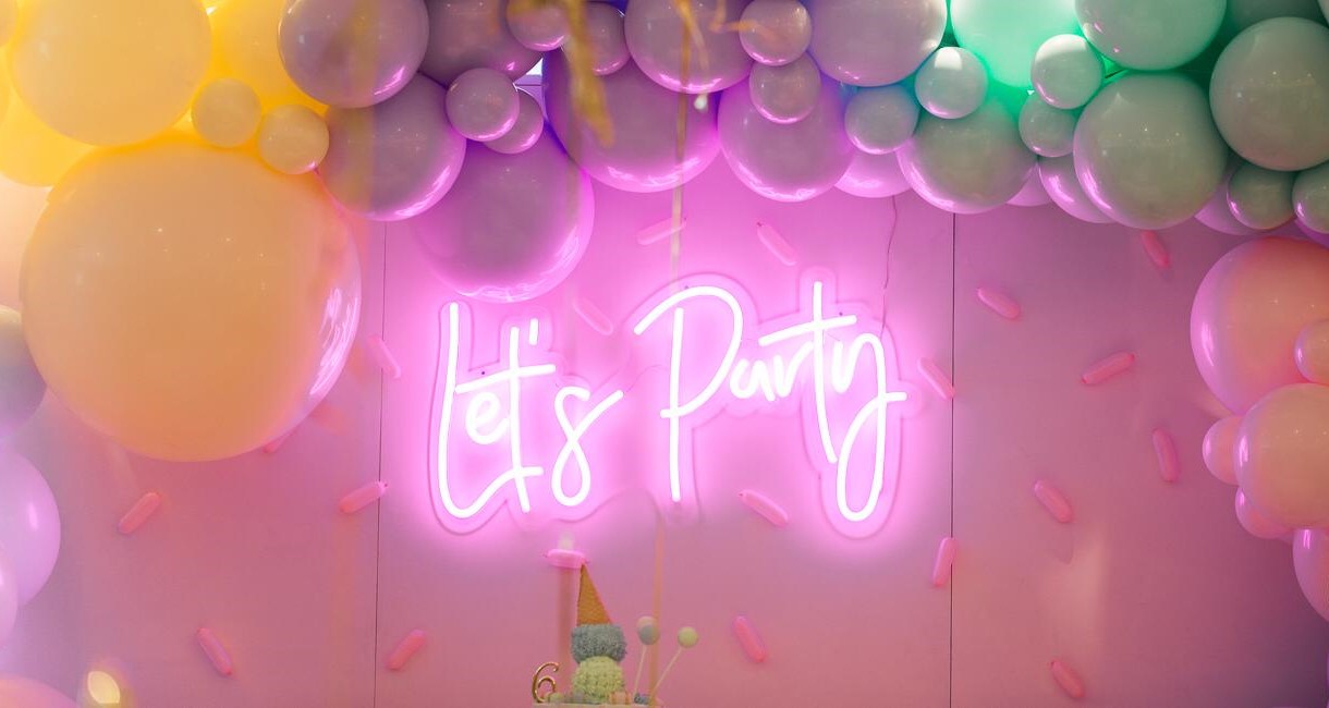 Custom Neon® pink Let's Party sign on clear acrylic