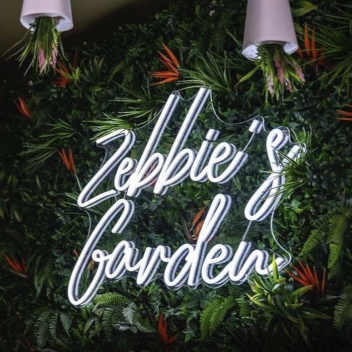White business name sign on green wall by Custom Neon® @leedesign